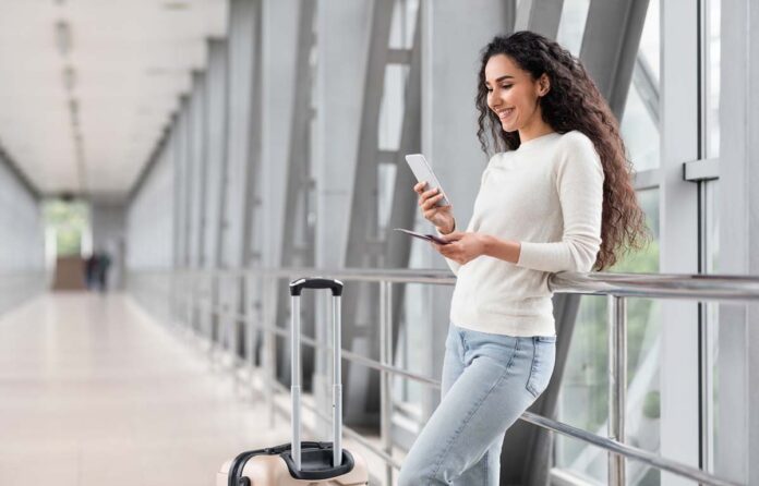 Portrait,Of,Beautiful,Young,Woman,Using,Smartphone,While,Waiting,At